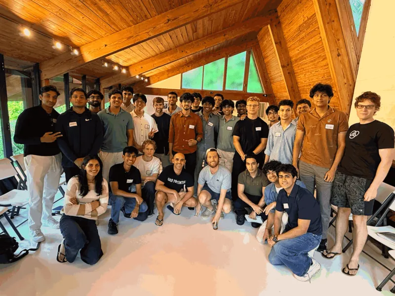The Telora S26 fellows, Malik among them, in an A-frame house in Miami, with Clem Delangue of Hugging Face kneeling in the front row.