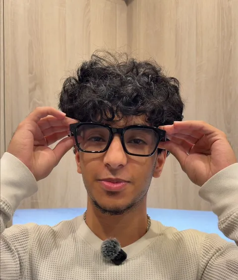 Malik putting on a pair of Meta smart glasses in a kitchen in Miami